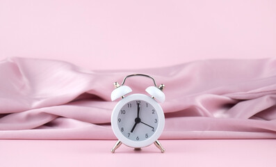 White watch on pink silk background.