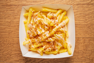 Fries are generously drizzled with a rich sauce, creating a mouthwatering snack perfect for sharing