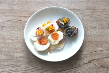 boiled salty and black preserved egg half cut with slice shallot and chili salad on plate