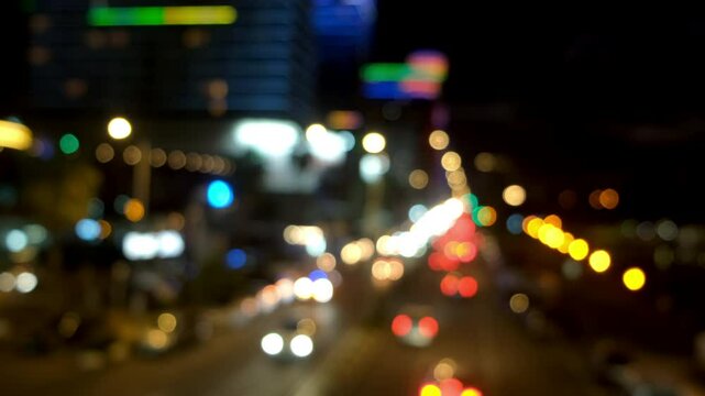 Blurred night city traffic with illuminated building and cars on road. Creating mesmerizing urban nightscape with dynamic light trails and vibrant metropolitan energy. Modern urban infrastructure.