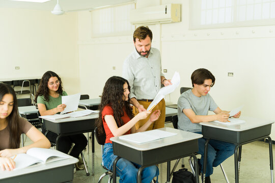 Teacher helping high school student with exam in classroom