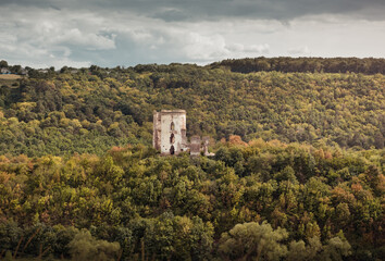 Fototapeta premium Chervonohorod Castle on a steep hill in the middle of the valley of the Dzhuryn river. Two tower ruins of abandoned castle near Nyrkiv, Ukraine.