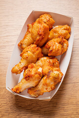 Deliciously crispy fried chicken wings presented in a takeout box, ideal for sharing and enjoying