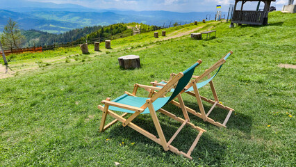 Empty loungers on hillside with scenic mountain view