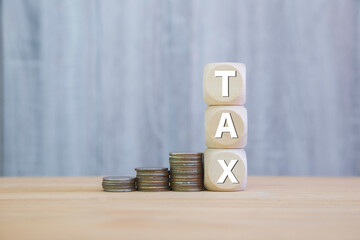 investment tax, stacking coins and tax icon at in wood, interest rates and dividends. retirement...