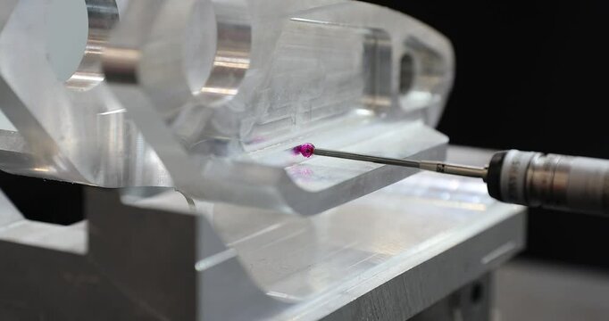 Slow motion 4k movie of a computerized measurement and control device of the dimensions of a metal engine block part with a probe stylus ball tip of multi-axis coordinate measuring machine.