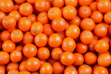 Vibrant tangerines piled high in a chaotic market display