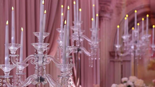 Modern glass candlesticks with white taper candles at a wedding.