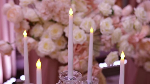 Modern glass candlesticks with white taper candles at a wedding.