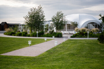 Modern outdoor venue with stylish architecture and a peaceful landscaped walkway