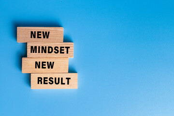 new mindset new result words text on wooden blocks isolated on blue background