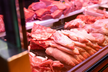 Display case in meat department of supermarket - raw pork legs are stacked