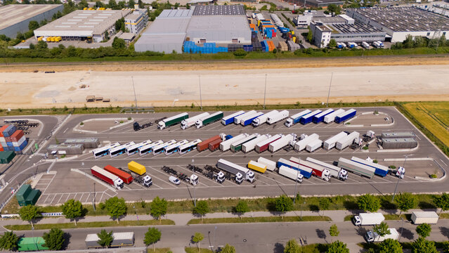 A large parking lot with many trucks and buses. Aerial view.