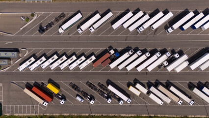 A large parking lot with many trucks and buses parked in rows. Aerial view. © Nikname