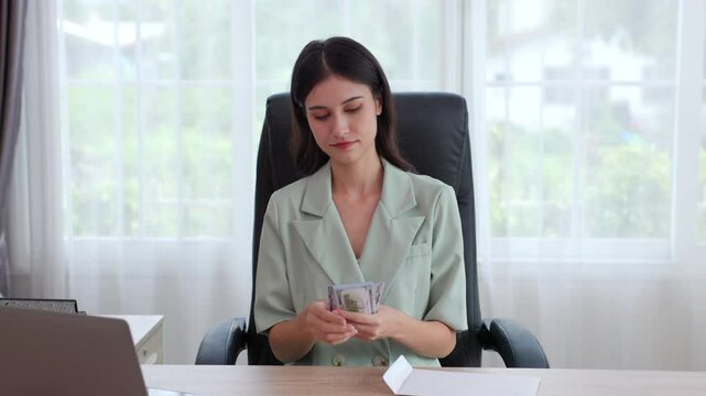 Businesswoman counting money from white envelope in the office
