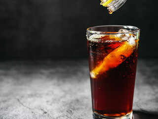 Pouring of Cola and Ice, Cola soft drink with ice cubes, soda fizzy drink in Cold glass