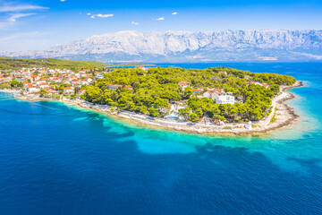 Drone view of Sumartin, a picturesque coastal village on Brac Island, Croatia, captures the charming harbor, traditional stone houses, and crystal-clear waters of the Adriatic Sea