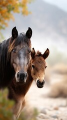 Horses grazing peacefully in a serene landscape during early morning light with soft focus on scenic background