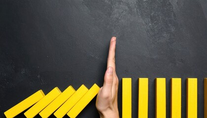 Hand stopping falling blocks as a metaphor for intervention, risk management and damage control