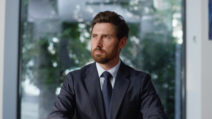 Successful executive sitting cabinet closeup. Bearded businessman looking camera