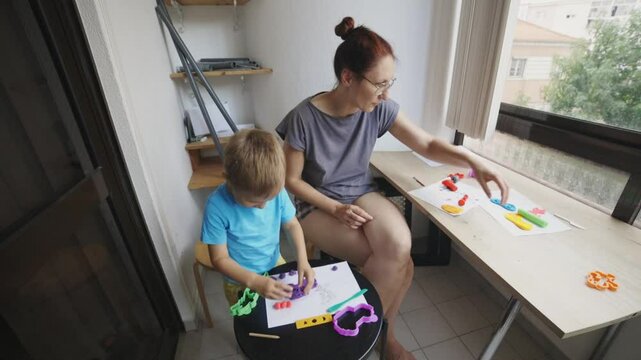Mother and son creating colorful clay art at home