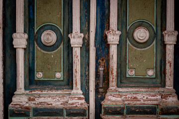 Closeup of blue turquoise old textured antique door with gold bronze door handle and keyhole.