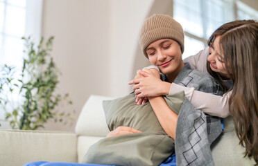 Cancer patient receiving emotional support and care from loved family during chemotherapy recovery,...