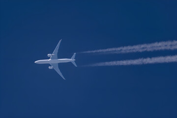White passenger airplane flying in blue sky leaving contrail