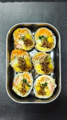 Sushi roll with pork, egg and vegetables on black background. Sushi roll with tuna, egg and vegetables. Japanese food. 