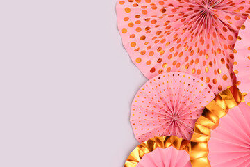 Pink paper fans texture on a blue background. Holidays decorations with copy space.