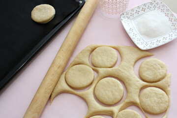 Cutting cookies from raw dough on table.
The raw cookies lying on a kitchen table. Horizontal  shot.