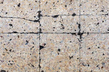Cracked concrete surface with aggregate stones