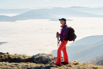 A female mountaineer, equipped with professional gear, enjoys the thrill of her climb as she...