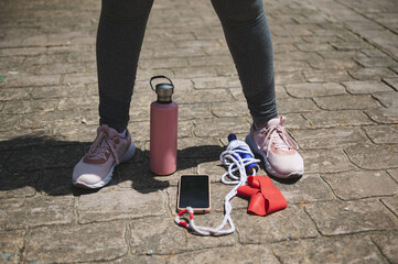 Fitness Accessories Placed on Pavement with Pink Sneakers for Morning Workout Routine