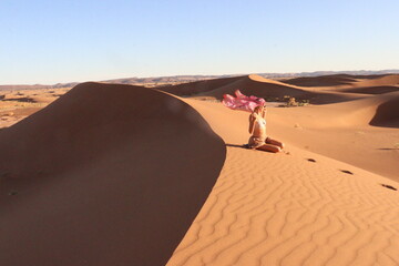 Beautiful woman in the dunes of the desert