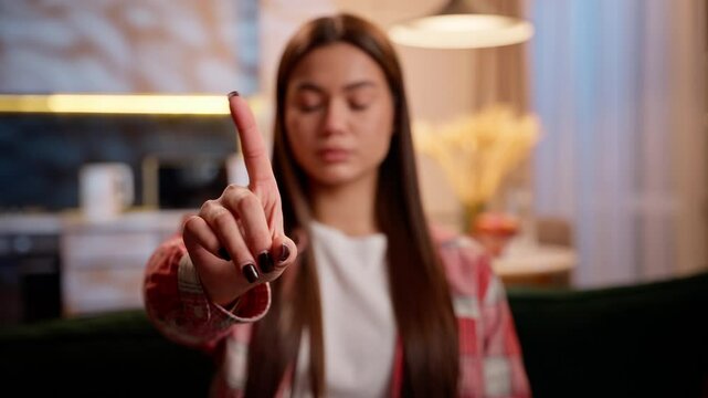 Serious Caucasian woman dissatisfied female teenager at night evening home shaking finger no hand gesture negative refusal rejection disapproval sign displeasure upset frustrated girl in apartment