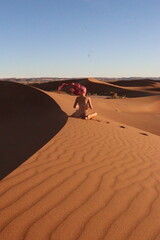 Woman doing yoga pose in the desert dunes