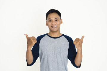 A cheerful individual wearing a casual shirt smiling confidently and gesturing with thumbs up.