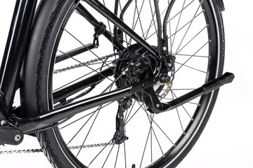 Studio shot of an electric motor and gears on rear e-bike hub close-up, details of the chain, spokes, and gears.