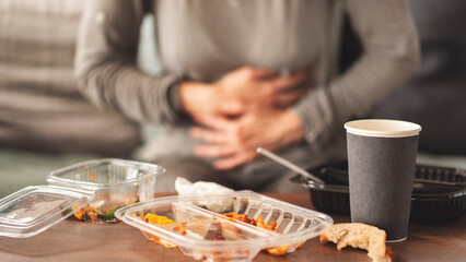 Woman with bloating and stomach pain after fast food meal