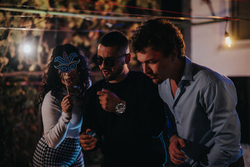 Friends celebrates together during a lively evening party outdoors with festive decorations, creating a joyous and relaxed social atmosphere filled with candid moments of friendship and laughter.