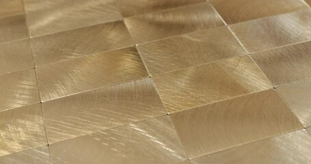 Seamless Rotating Gold Tile Texture Loop. Video showcasing a smooth, rotating pattern of luxurious gold tiles with a textured finish, ideal for dynamic design projects. - Powered by Adobe