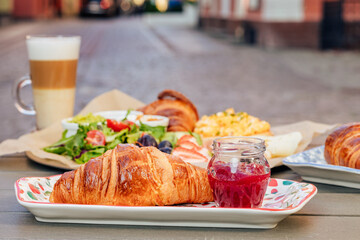 Fragrant croissant breakfast in a cozy old town on the summer terrace of an atmospheric cafe in Europe