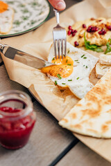 Action - an egg is appetizingly cut with a knife and fork during breakfast in an old European city