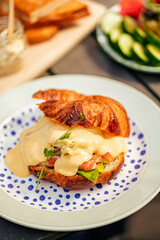 Fragrant croissant with cream cheese filling, red fish and egg, breakfast in a cozy old town on the summer terrace of an atmospheric cafe in Europe, action, hands