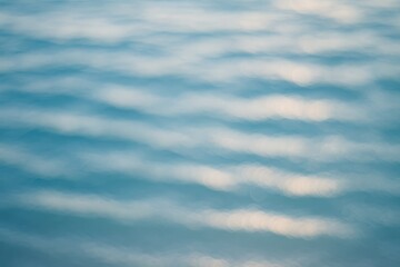Soft-focus aquatic scene featuring elegant white waves against a serene blue water backdrop