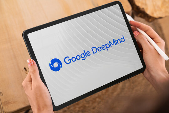 Woman holding tablet displaying google deepmind logo and website