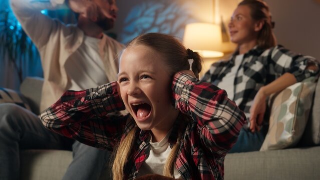 Family quarrel upset little child girl kid daughter closing ears with hands yelling screaming worry conflict problem at home evening parents arguing shouting angry domestic violence swearing abuse