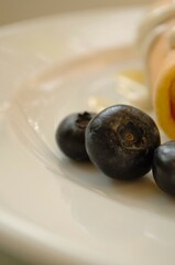 breakfast of fruits and pancakek on a white plate