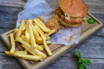   Home made  chicken Burger and   deep fried french fries on wooden   cuttingboard 